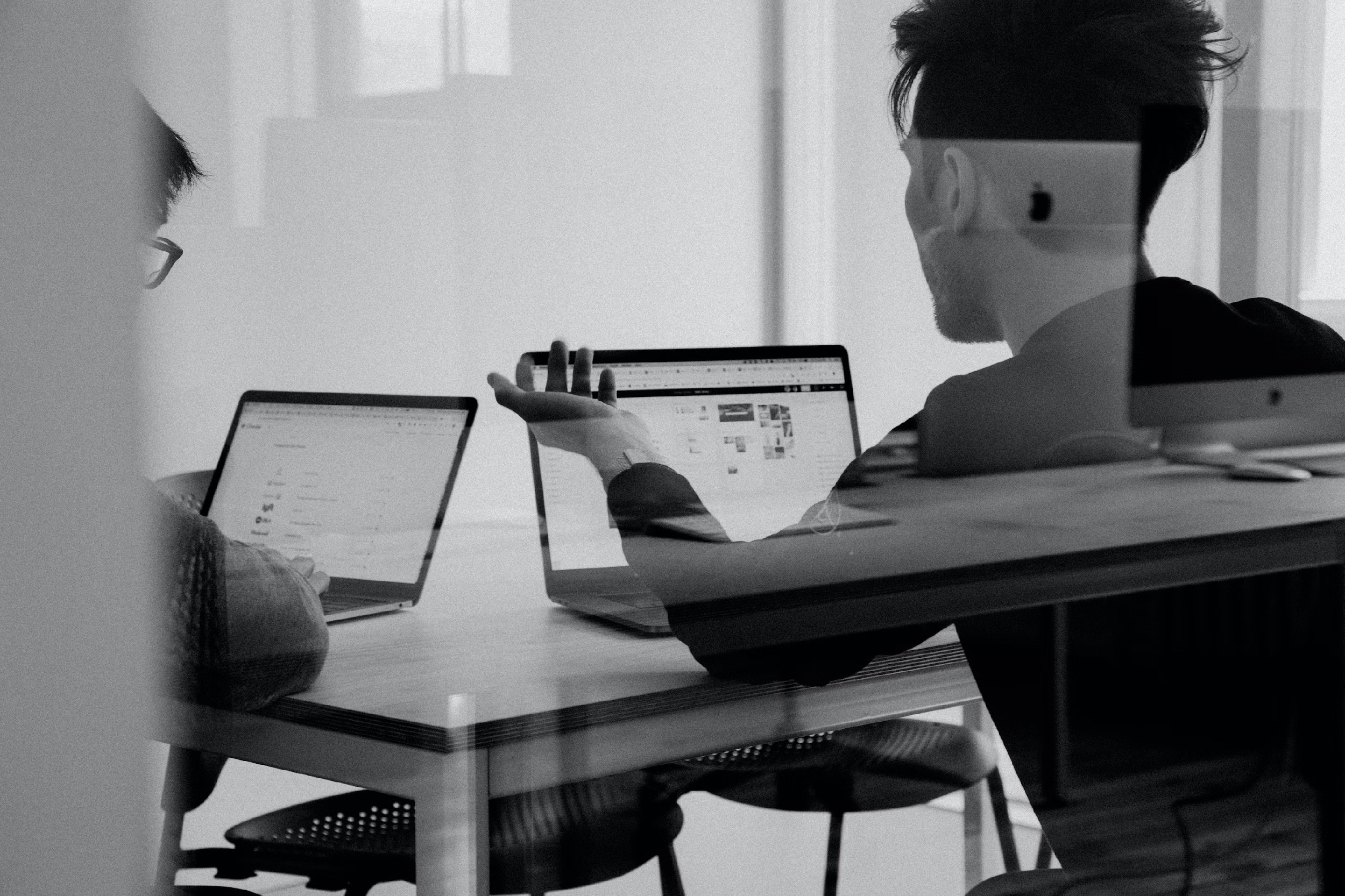 Personas trabajando en laptops durante una sesión de estrategia de marca en equipo.